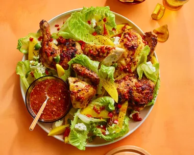 barbecue chilli chicken in with mango and lettuce salad in bowl, with sweet potato crisps on the side