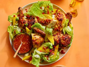 barbecue chilli chicken in with mango and lettuce salad in bowl, with sweet potato crisps on the side