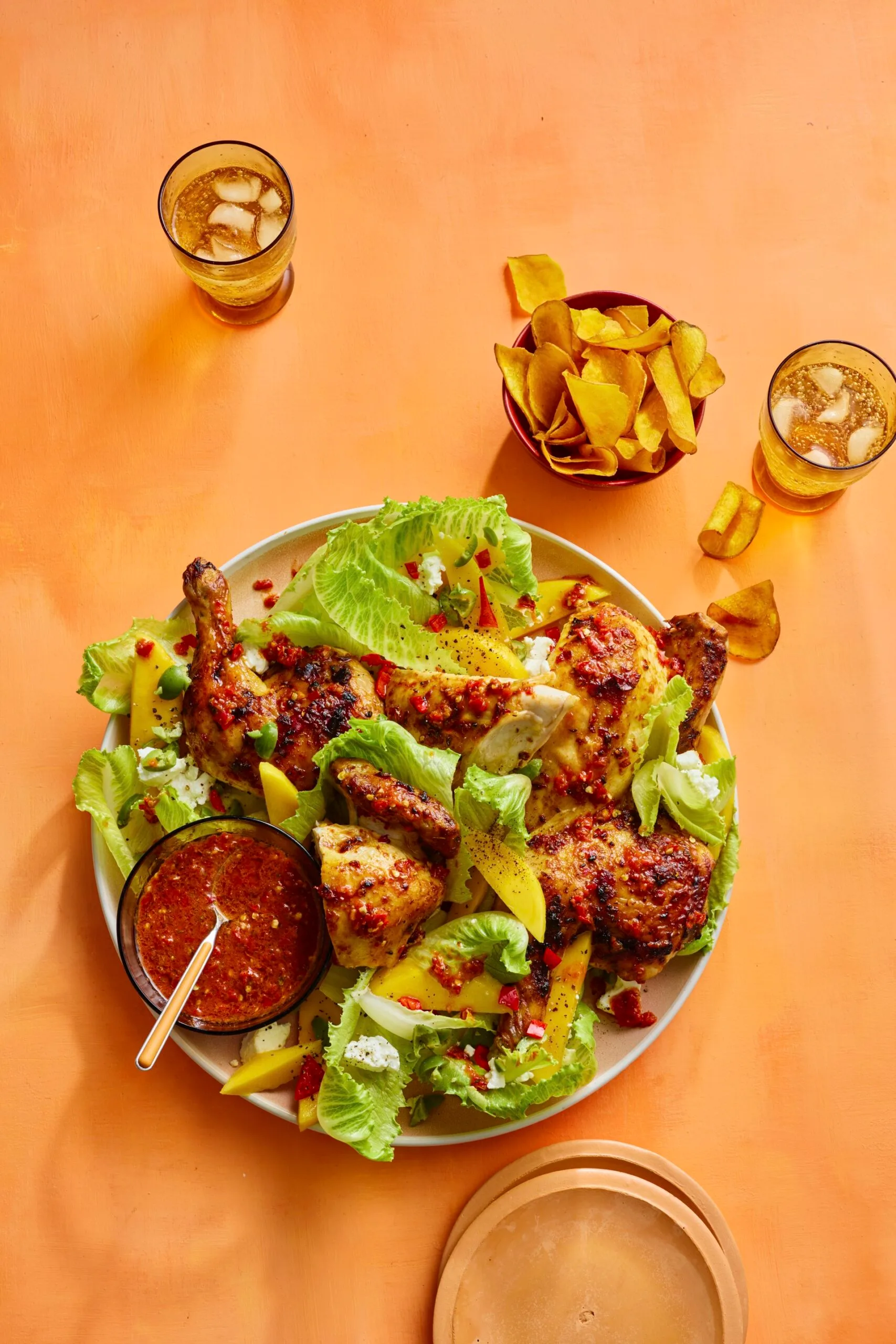 barbecue chilli chicken in with mango and lettuce salad in bowl, with sweet potato crisps on the side