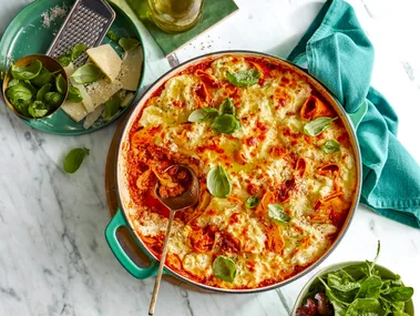 frying pan lasagne with basil sprinkled on top and mixed leaf salad on the side