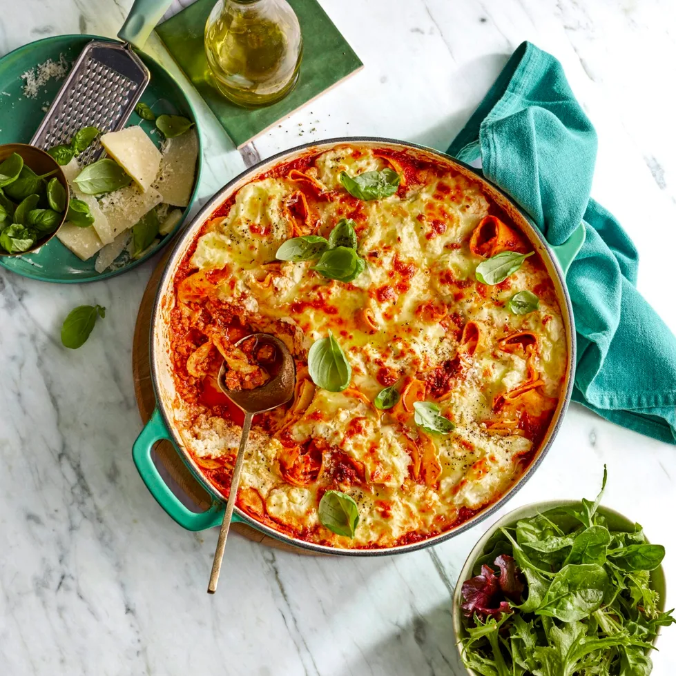 frying pan lasagne with basil sprinkled on top and mixed leaf salad on the side