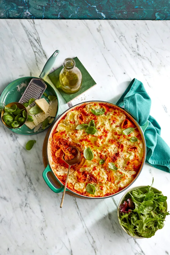 frying pan lasagne with basil sprinkled on top and mixed leaf salad on the side