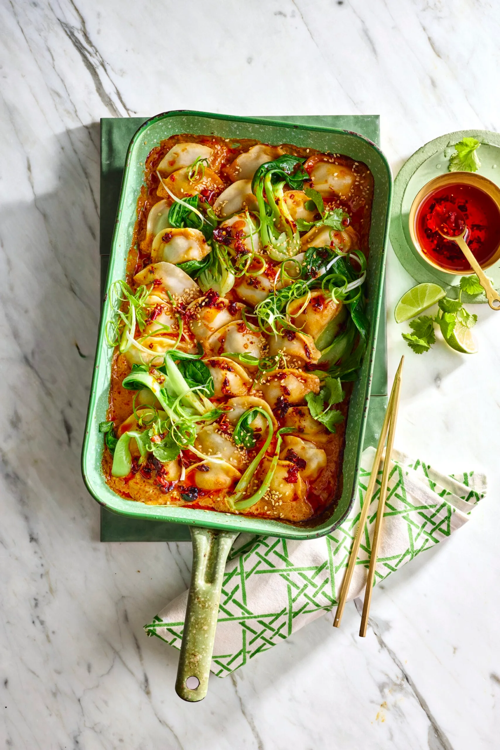 dumpling dump and bake with spring onion on top in a large baking dish with gold handle