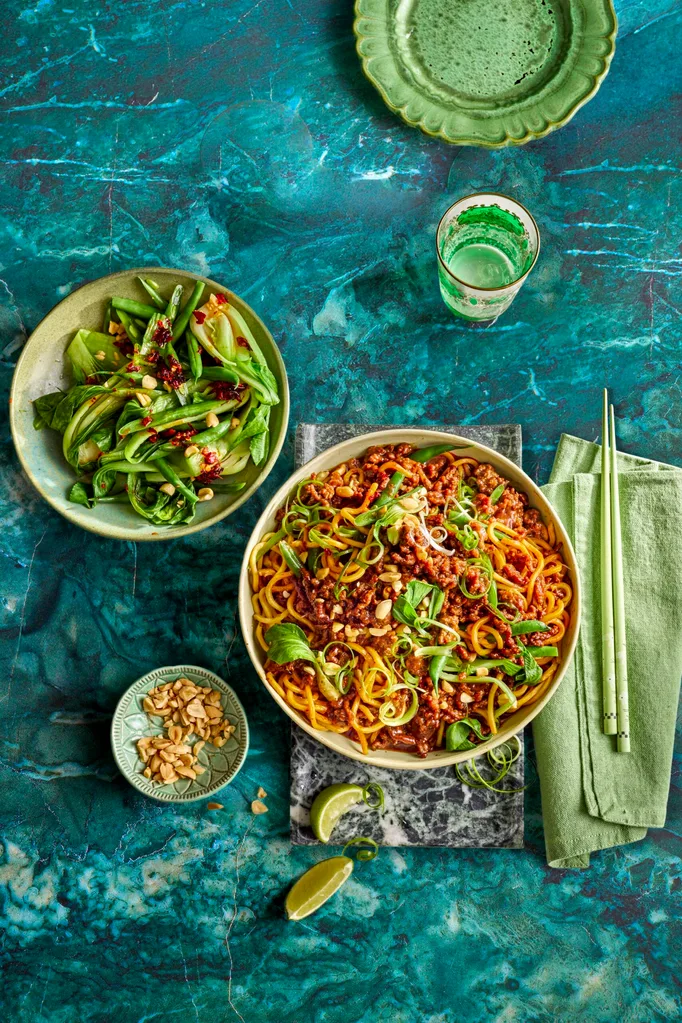 sticky mince beef noodles with asian herbs on top and mixed salad to the side