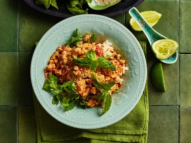 chicken larb in bowl with greens and blue bowl