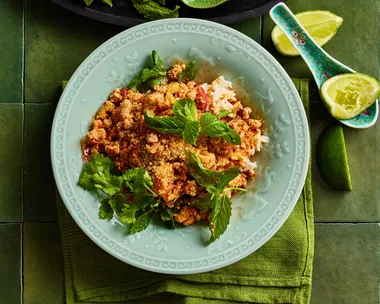 chicken larb in bowl with greens and blue bowl