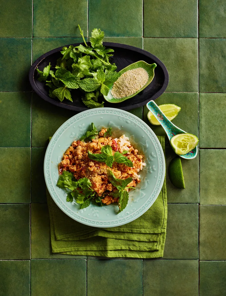 chicken larb in bowl with greens and blue bowl