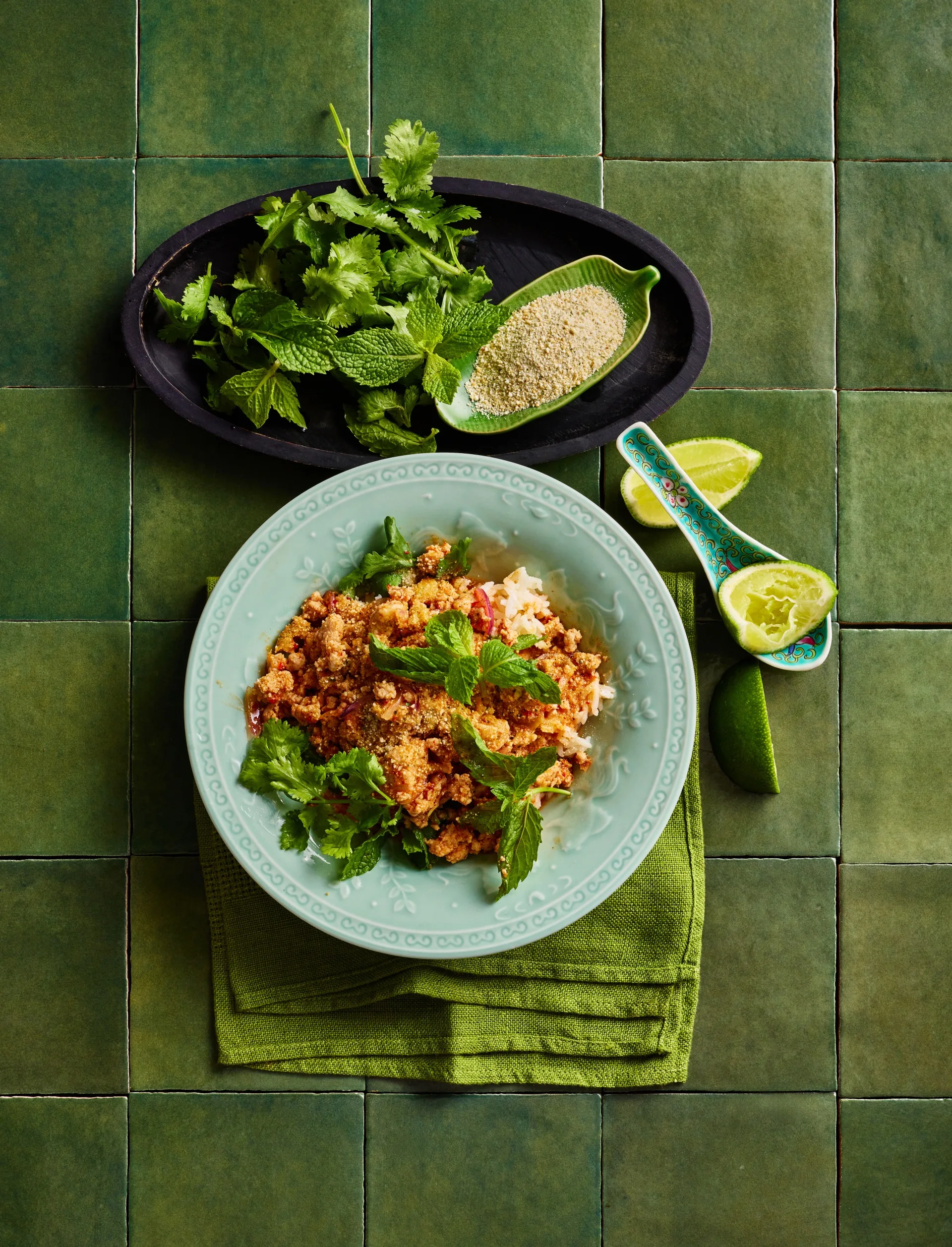 chicken larb in bowl with greens and blue bowl