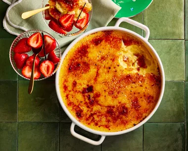 creme brulee in large pot for sharing with strawberries on the side