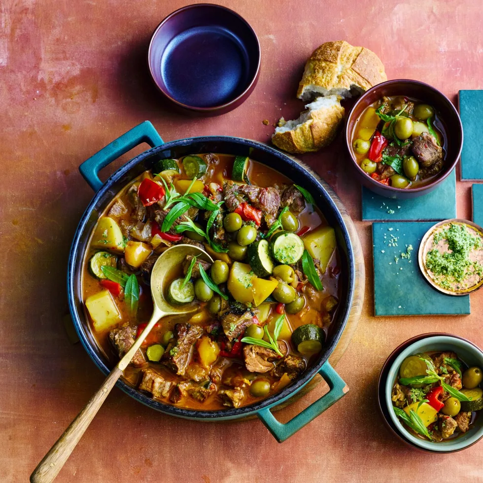 colin fassnidge's lamb ragu in giant bowl with wooden spoon and herbs on top