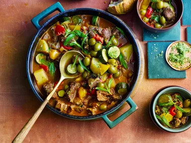 colin fassnidge's lamb ragu in giant bowl with wooden spoon and herbs on top