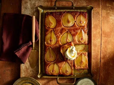 pear upside down cake with slices of pear in top of cake in metal rectangular tray