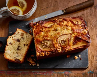 pear and chocolate loaf cake with pear and hazelnut indented on top and slice cut out to show cross section