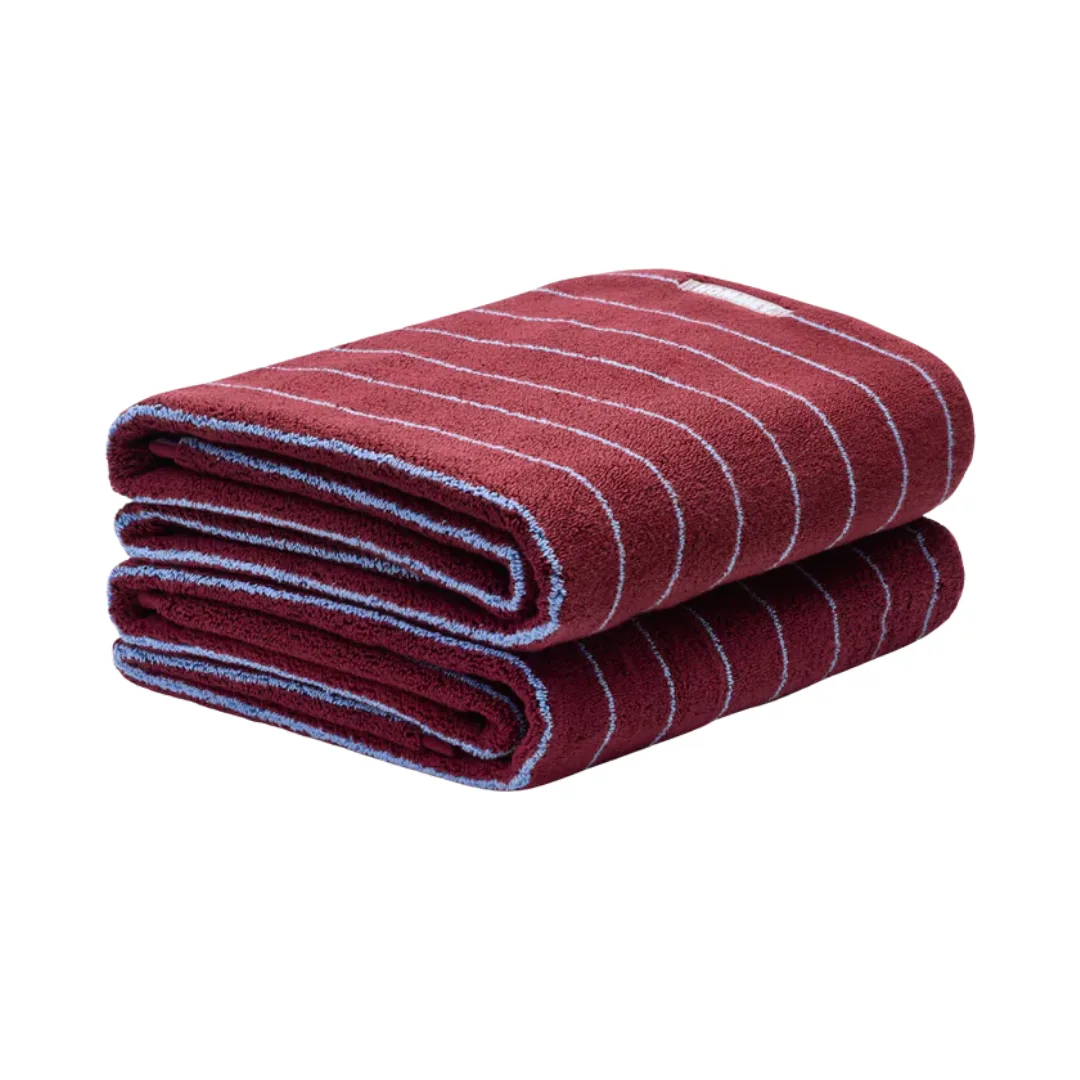 Two wine coloured bath sheets with thing blue stripes and the Hoppey logo stitched on top
