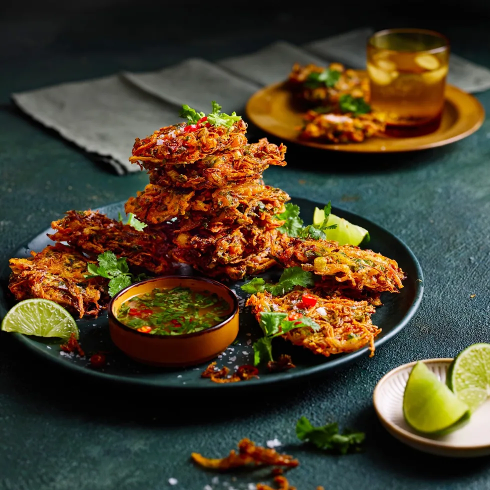 vegetable bhajis piled high on plate with slice of lime