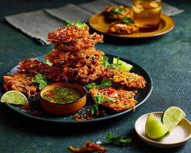 vegetable bhajis piled high on plate with slice of lime