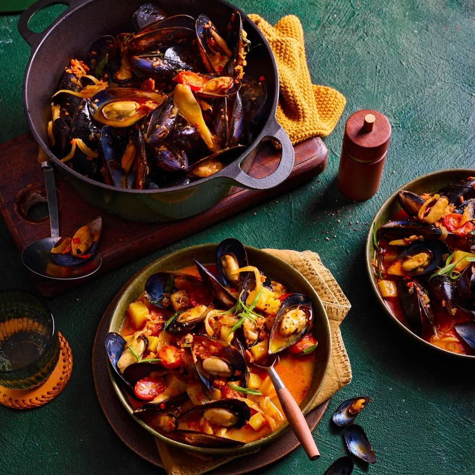 nduja mussels in pan with spoon sticking out and orange liquid sauce