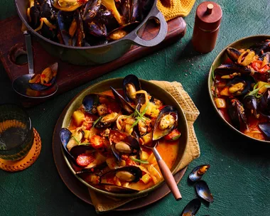 nduja mussels in pan with spoon sticking out and orange liquid sauce