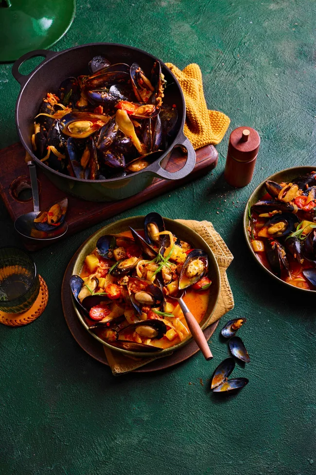 nduja mussels in pan with spoon sticking out and orange liquid sauce
