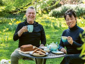 Jimmy Barnes and Jane Barnes drinking tea togerther outdoors at their home