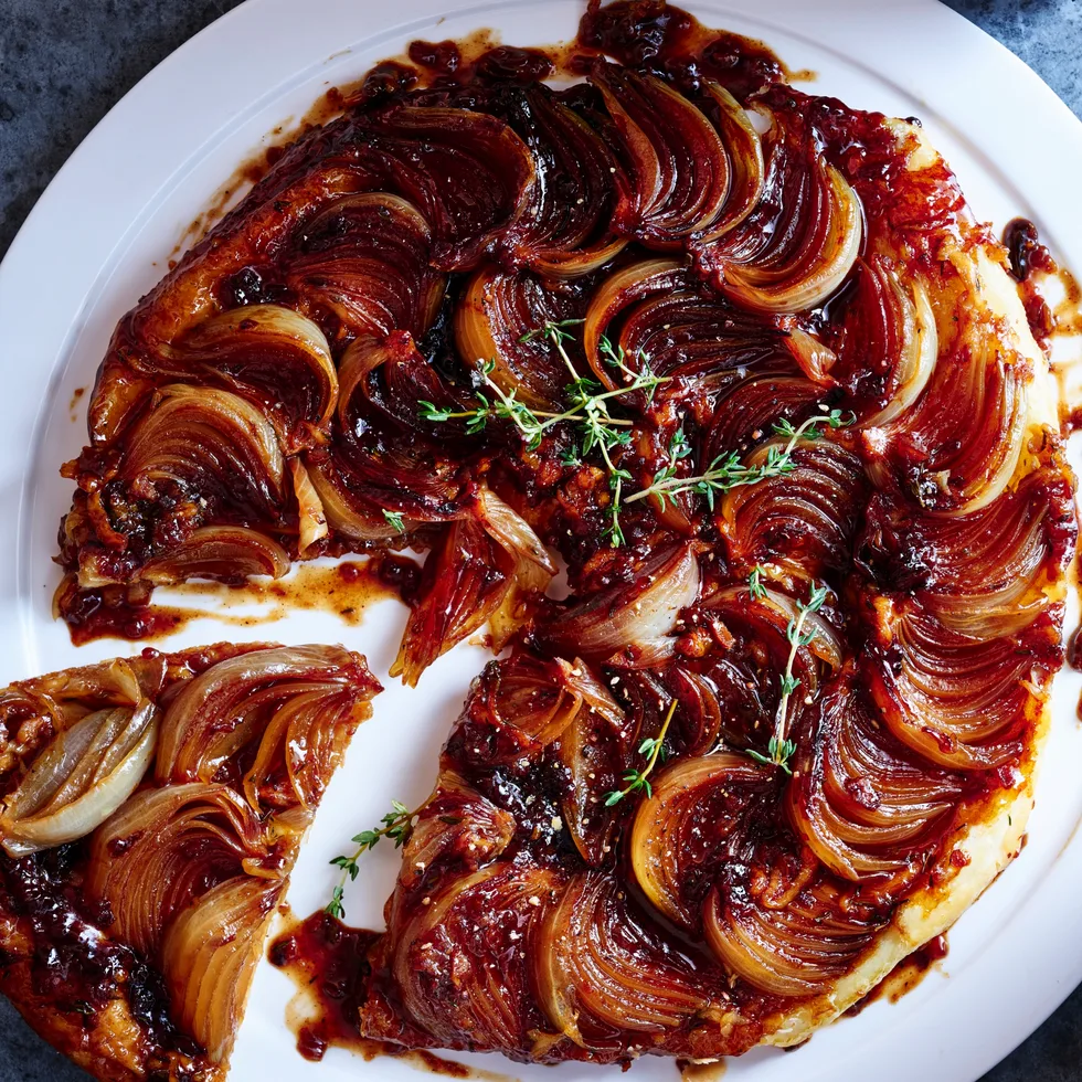 french onion soup mix tarte tatin with onions caramelised on top of tart and single slice cut out