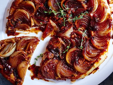 french onion soup mix tarte tatin with onions caramelised on top of tart and single slice cut out