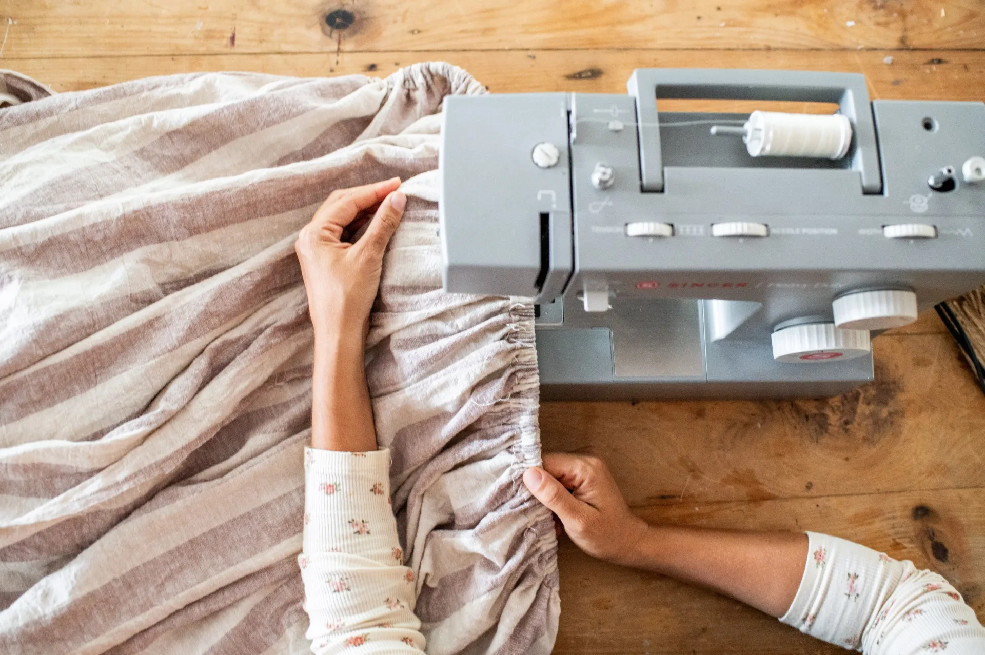 Geneva Vanderzeil sewing a craft trolley storage skirt with a sewing machine
