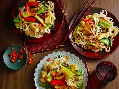 midweek stir fry with tofu in three separate bowls with red cloth underneath
