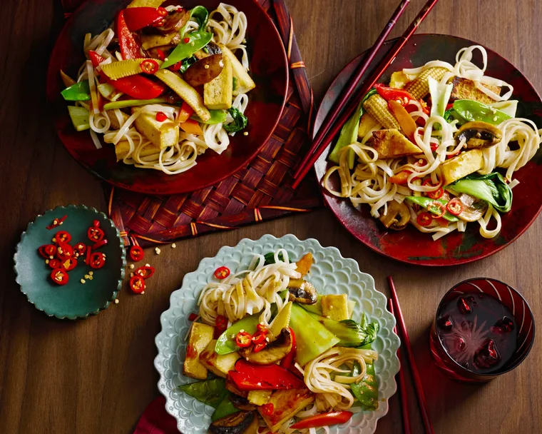 midweek stir fry with tofu in three separate bowls with red cloth underneath