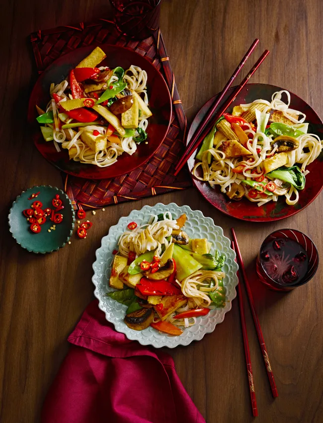 midweek stir fry with tofu in three separate bowls with red cloth underneath