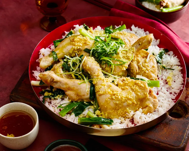 steamed ginger chicken marylands in red bowl on a bed of rice with herbs on top