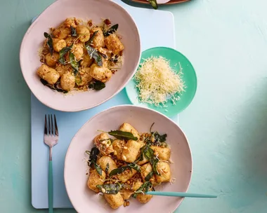 colin fassnidge's ricotta gnudi is on two white bowls with herbs sprinkled around them