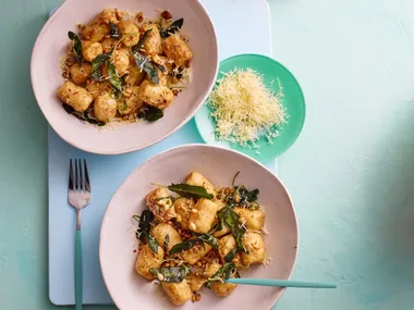 colin fassnidge's ricotta gnudi is on two white bowls with herbs sprinkled around them