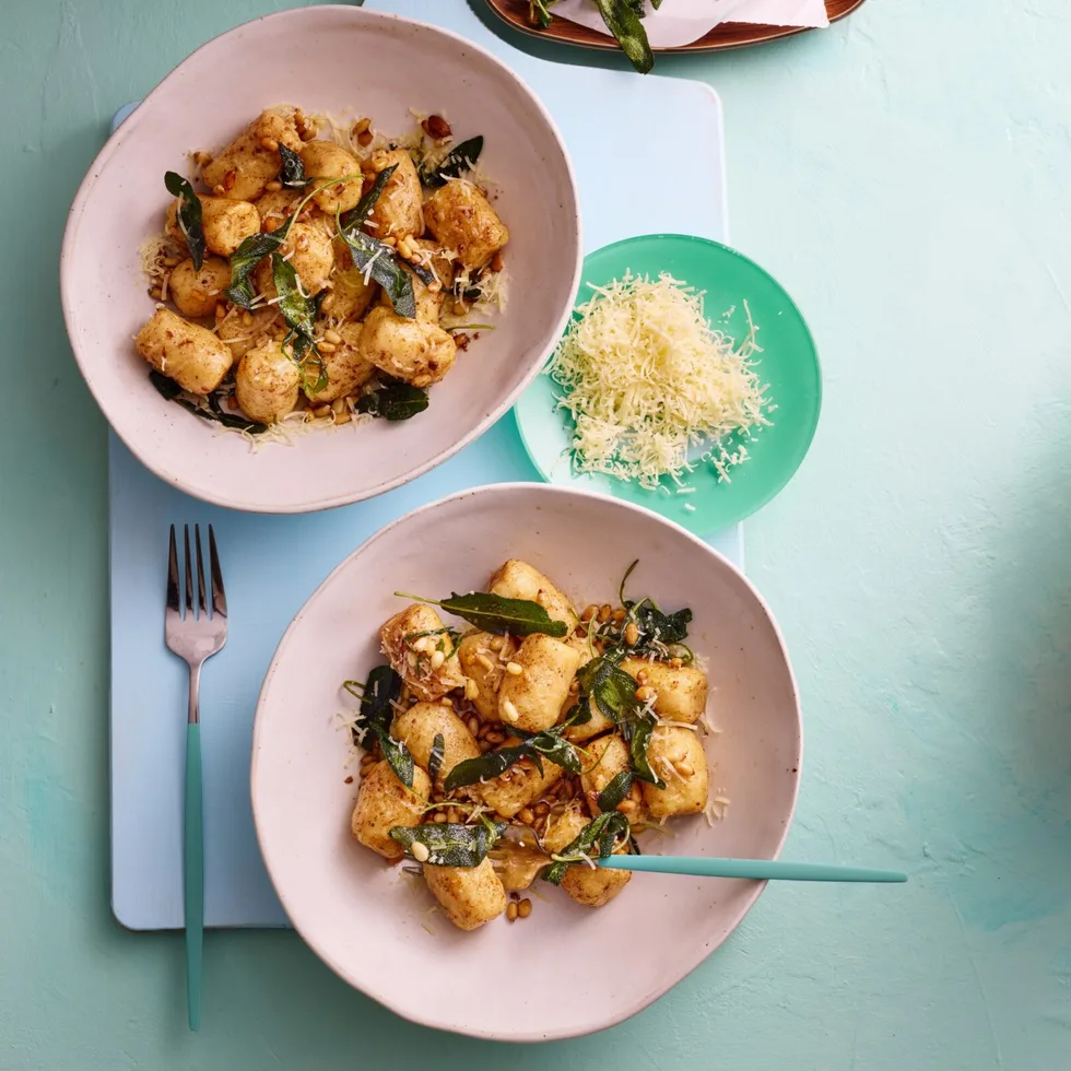 colin fassnidge's ricotta gnudi is on two white bowls with herbs sprinkled around them