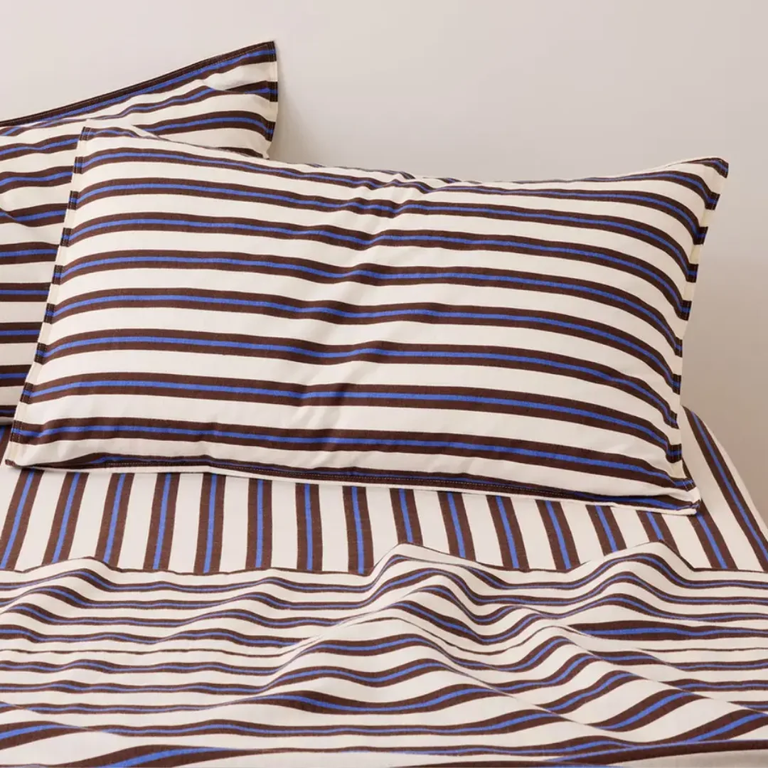 Image of a bed with a blue, cream, and burgundy striped flannelette fitted sheet, flannelette top sheet and pillowcases from Sheet Society