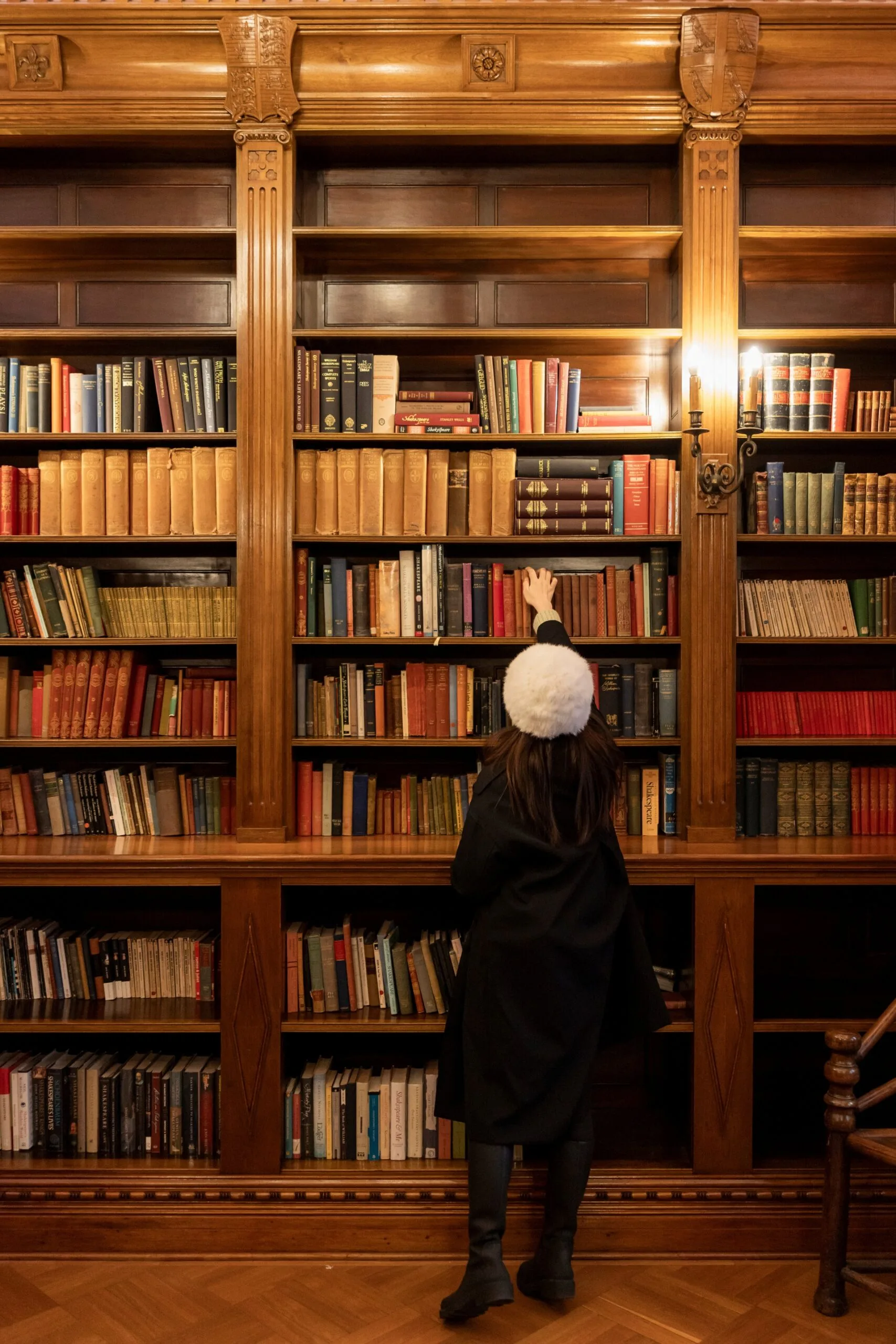 shakespeare room at state library of nsw with older lady reaching for book on shelves
