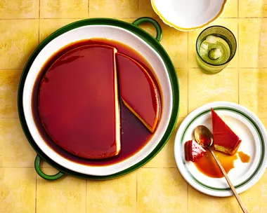 colin fassnidge's creme caramel cheesecake with slice cut out on separate plate sitting on bright tile like background