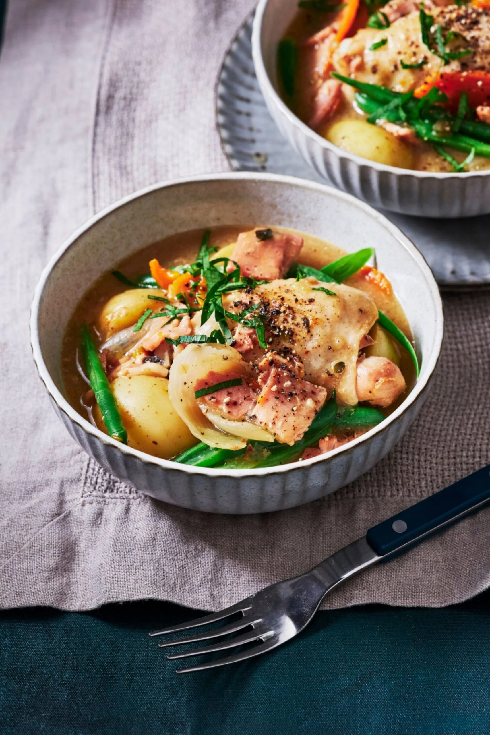 slow cooker french onion chicken casserole in bowl with sprinkle of herbs on top and green beans