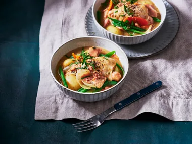 slow cooker french onion chicken casserole in stripy white bowls with white tablecloth underneath