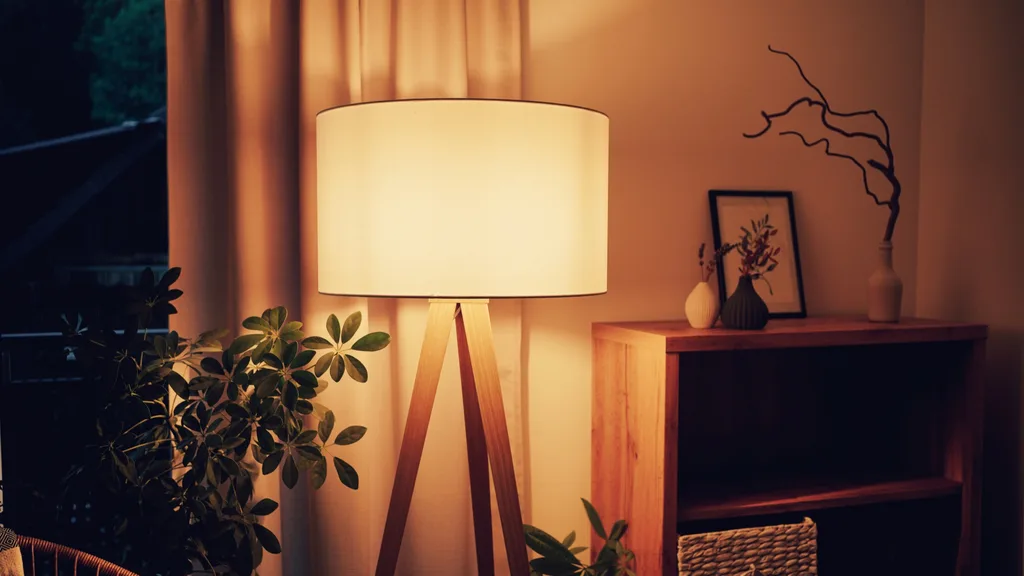 glowing standing lamp with white curtains and several indoor plants