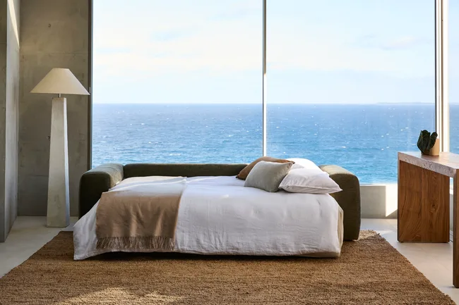sofa bed with bed brought out and brown blanket on it