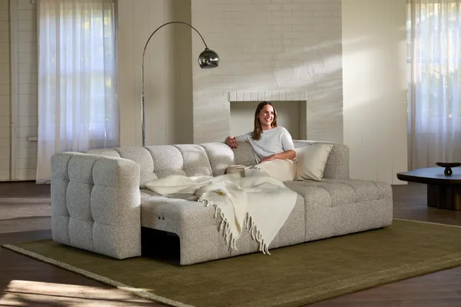 sliding seat sofa in white with lady reading sitting on it