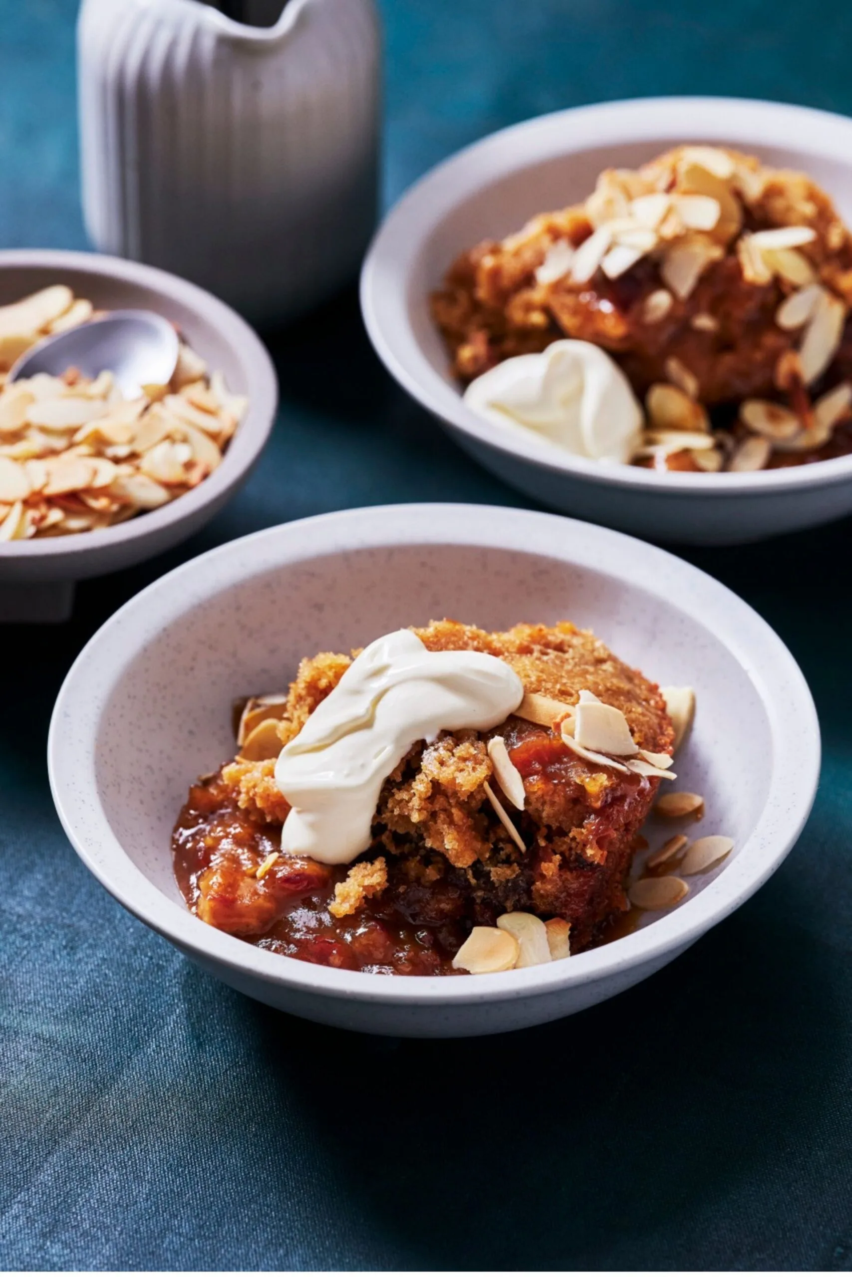 slow cooker sticky date pudding close up of bowl with cream on top