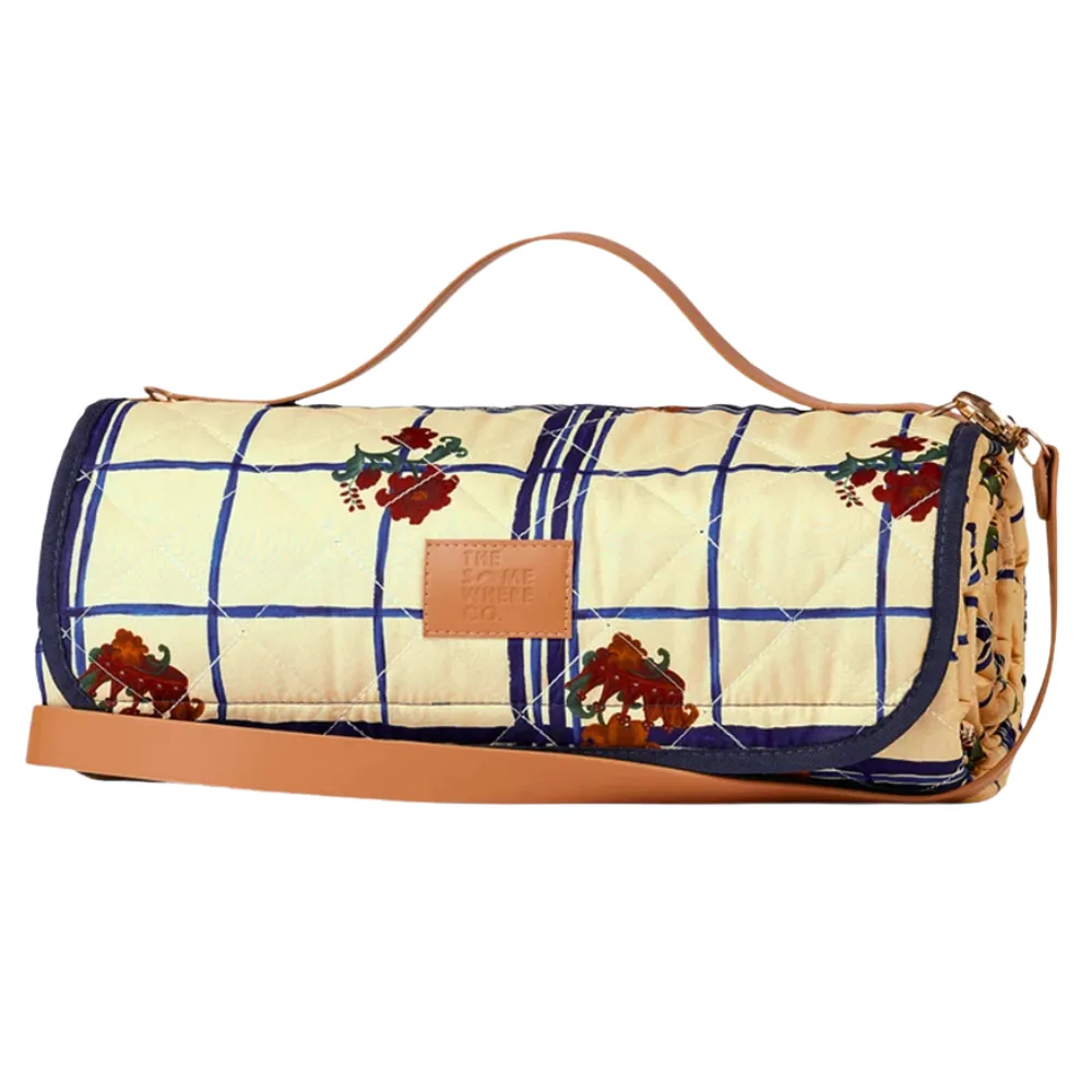 the gatherer picnic blanket rolled up with handle in blue and cream check pattern with roses