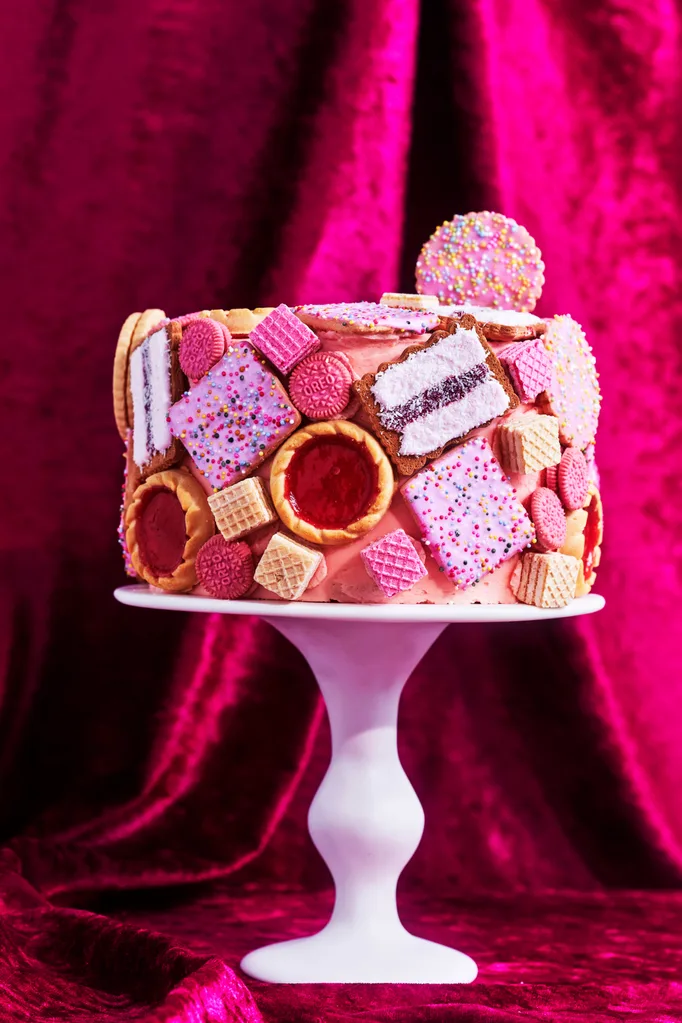 biscuit cake hack with pink icing and biscuit dotted over the cake