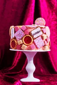 biscuit cake hack with pink icing and biscuit dotted over the cake