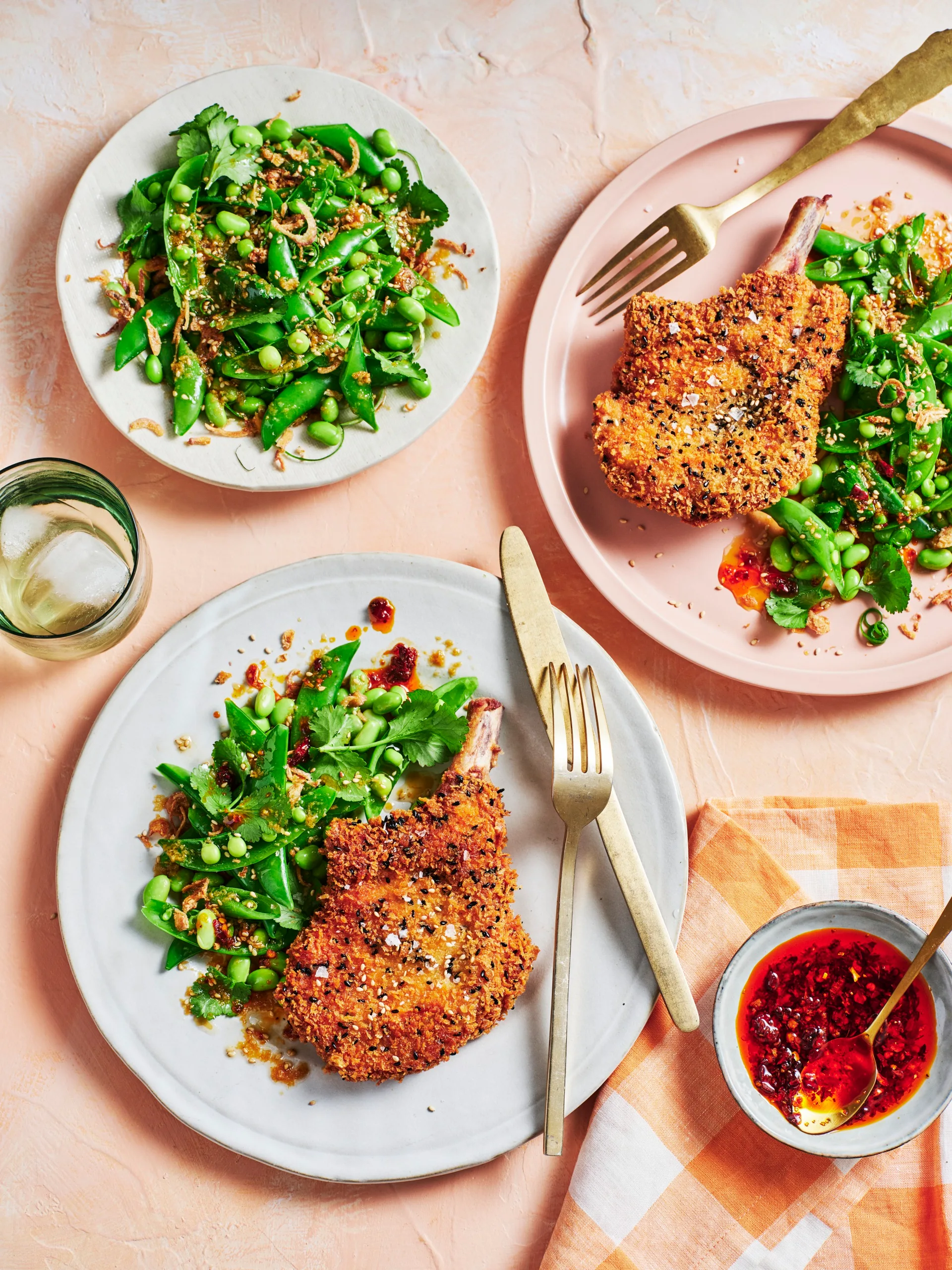 clarissa feildel's crumbed pork cutlets on plate with spring green salad of peas and edamame on the side