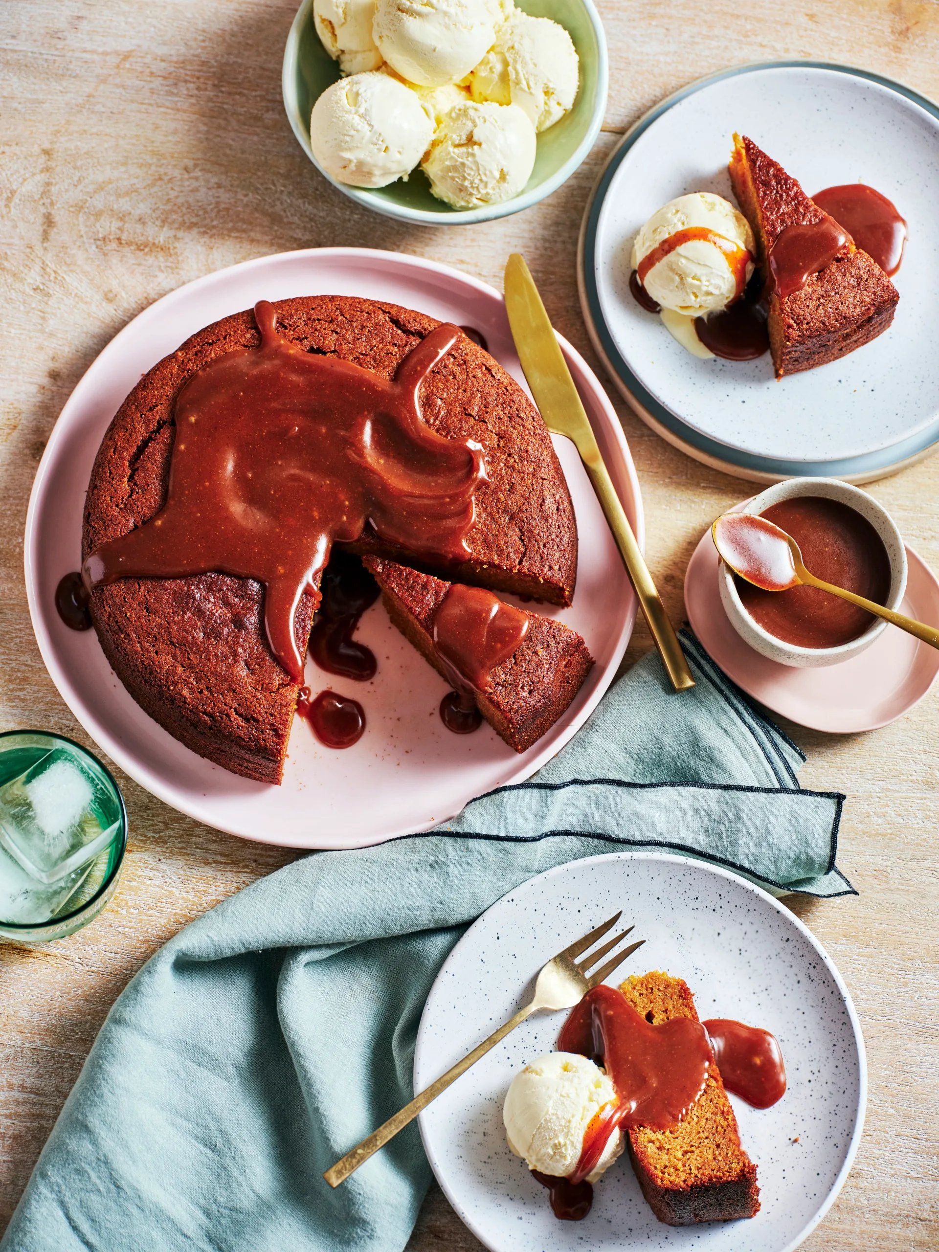 clarissa's sweet potato cake with syrupy glaze on top and piece cut out of it. a plate on the side has a scoop of icecream with piece of cake