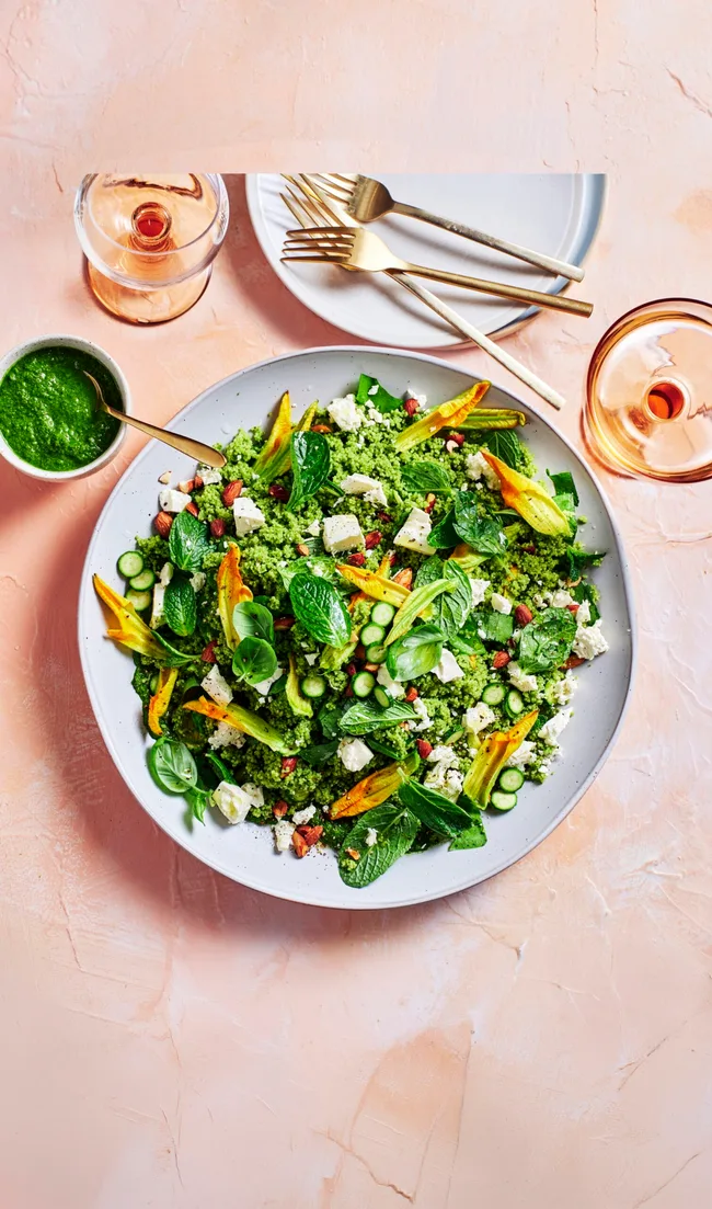 spring green couscous with kale spinach apple and sorrel sitting in bowl on pink background