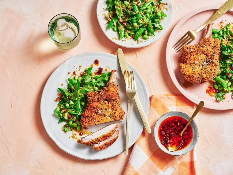 clarissa feildel's crumbed pork cutlets on plate with spring green salad of peas and edamame on the side